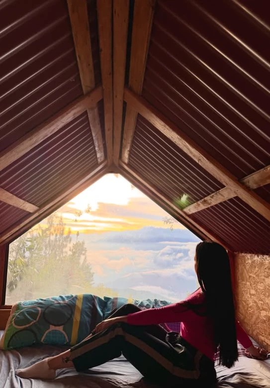 Cabin at the Cerro Kennedy high camp looking out over the clouds at sunrise